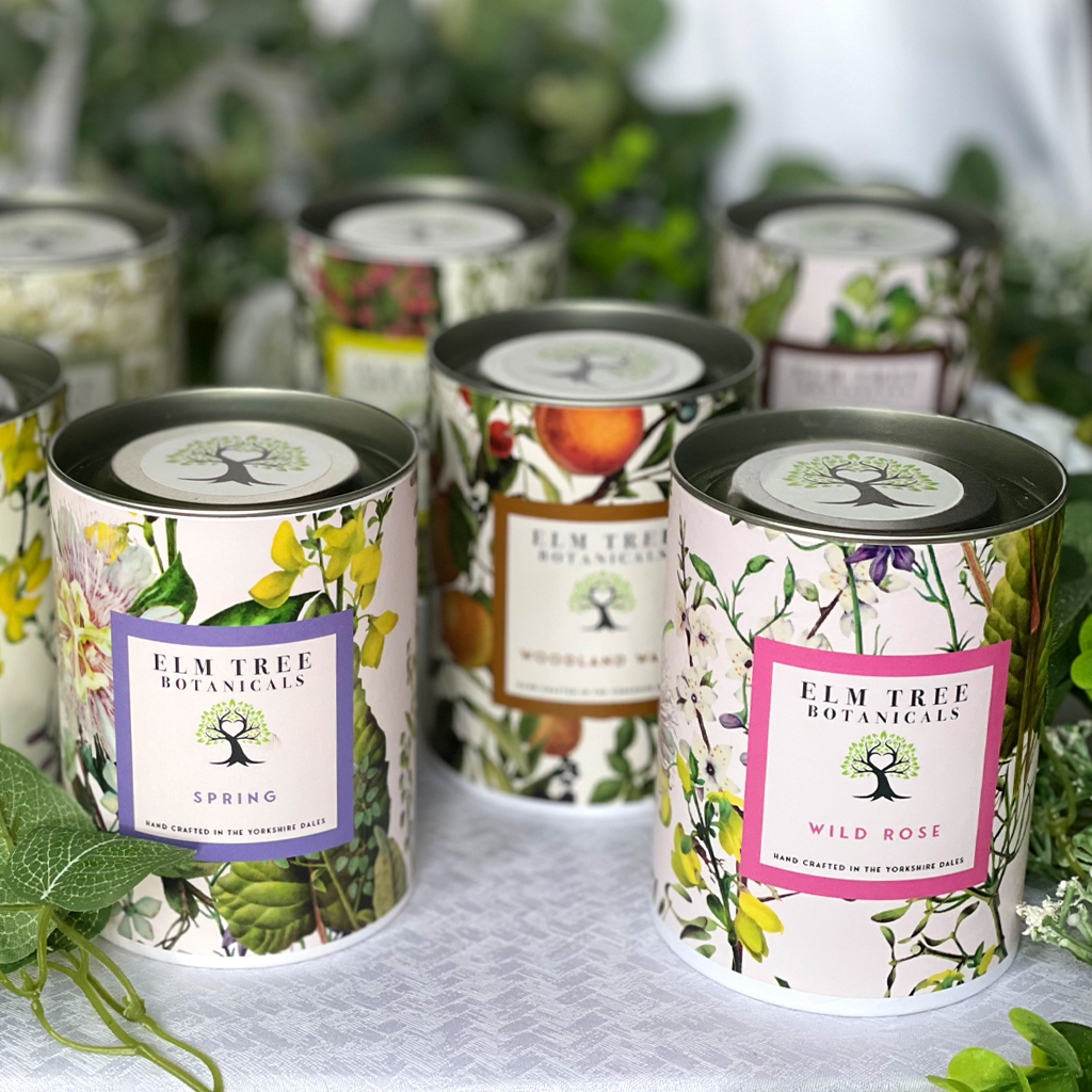 A collection of candles presented in branded packaging.